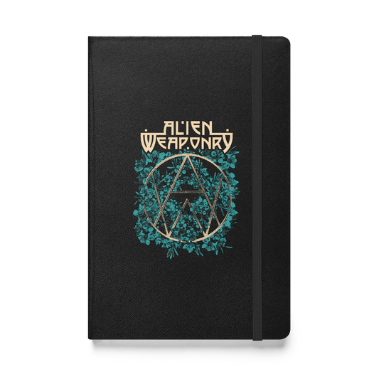 A black hardcover notebook featuring a metallic gold and teal graphic of the band Alien Weaponry logo on the front, set against a plain white background.